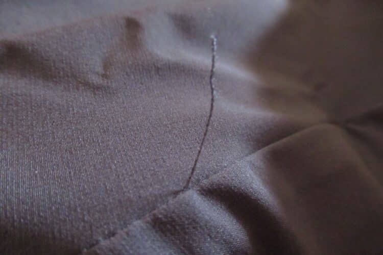 Grand fil qui dépasse au niveau de l'entre-jambe du pantalon Claret F