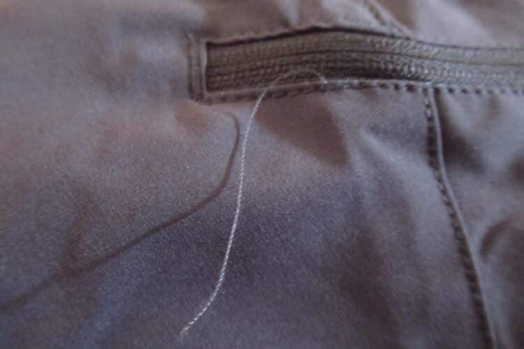 Grand fil qui dépasse d'un zip de poche du pantalon CimAlp